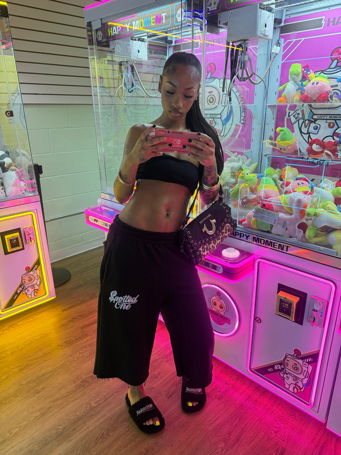 Black Spotted One long shorts styled at an arcade