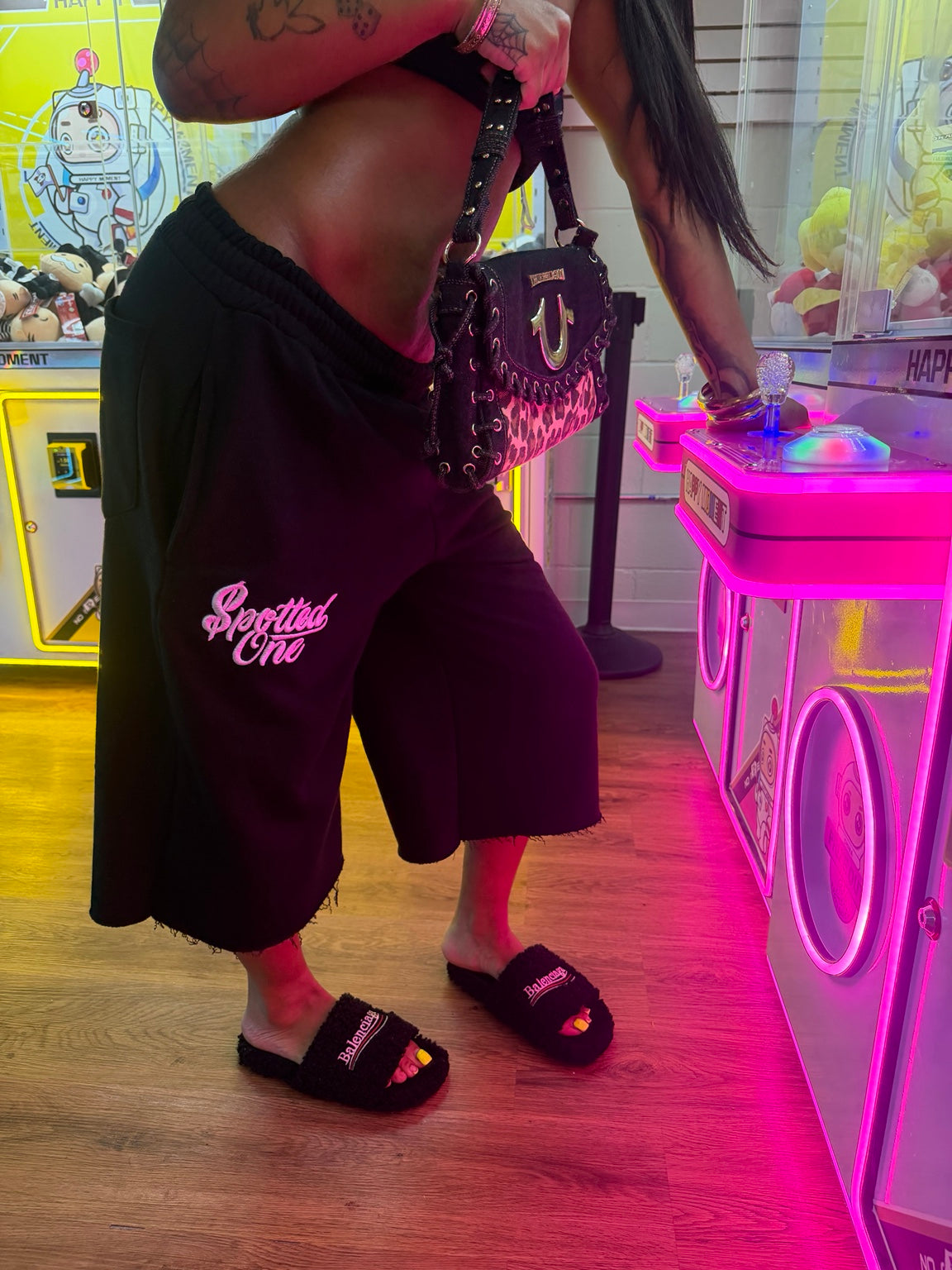 Black Spotted One long shorts styled at an arcade